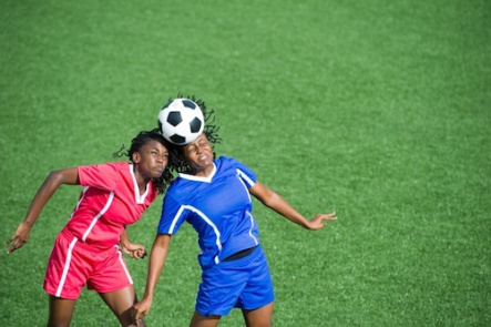Two female soccer players competing for the ball, aerial view.