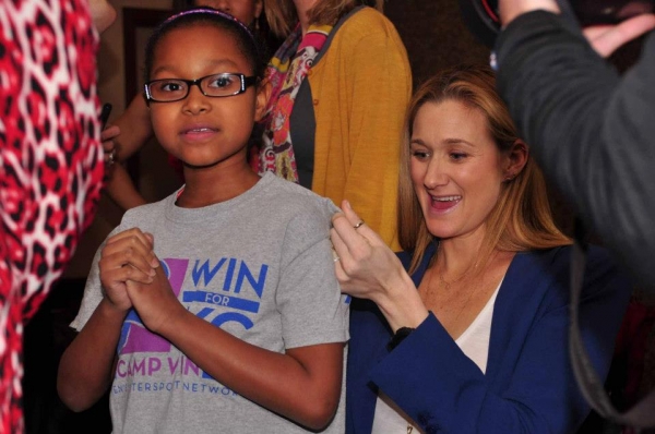 Kerri Walsh Jennings signing the shirt of a young WIN for KC supporter