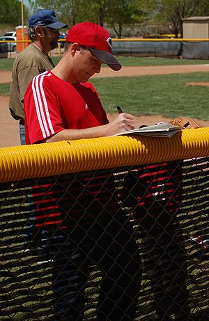 English: A tee ball coach setting the lineup a...